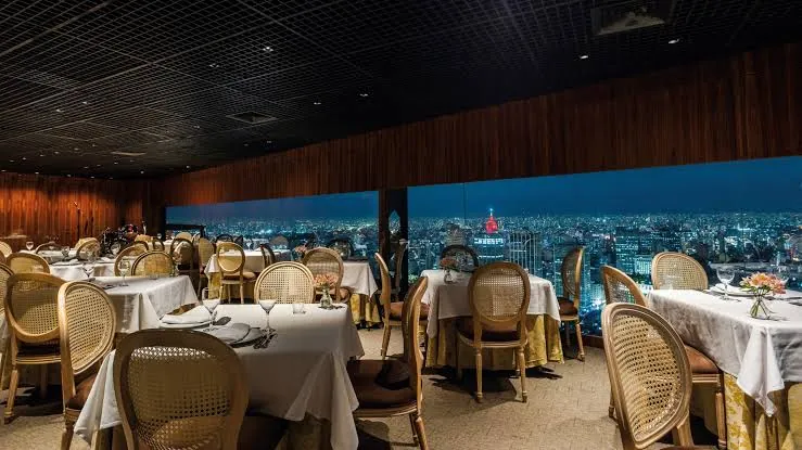 Salão do Terraço Itália à noite com mesas servidas